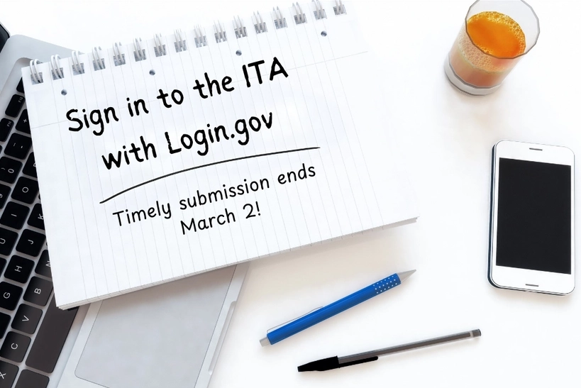 Notepad with "Sign in to the ITA with Login.gov - Timely submission ends March 2!" written on it