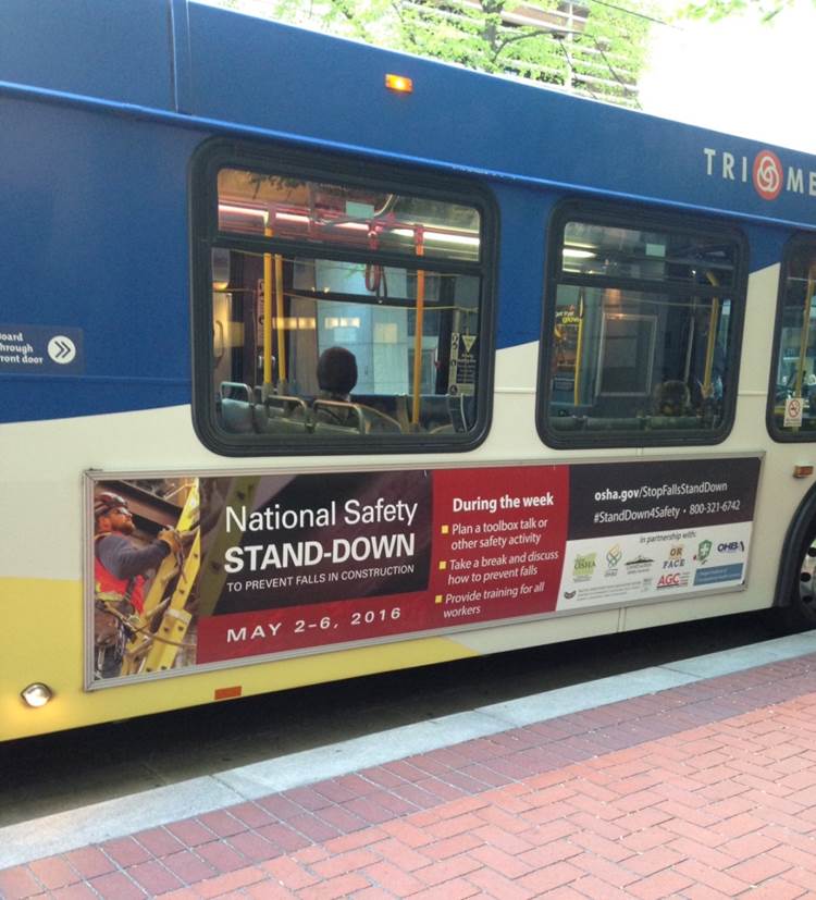 City bus with 2016 National Safety Stand-Down to Prevent Falls in Construction poster on its side