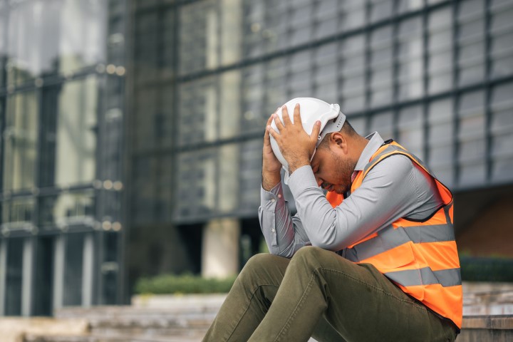 Construction worker with head in hands