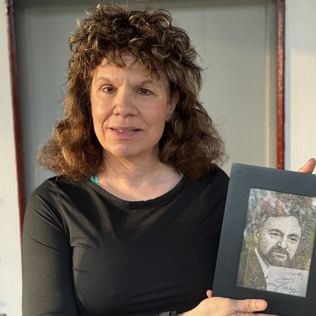 Individual holding up photo of a fallen worker