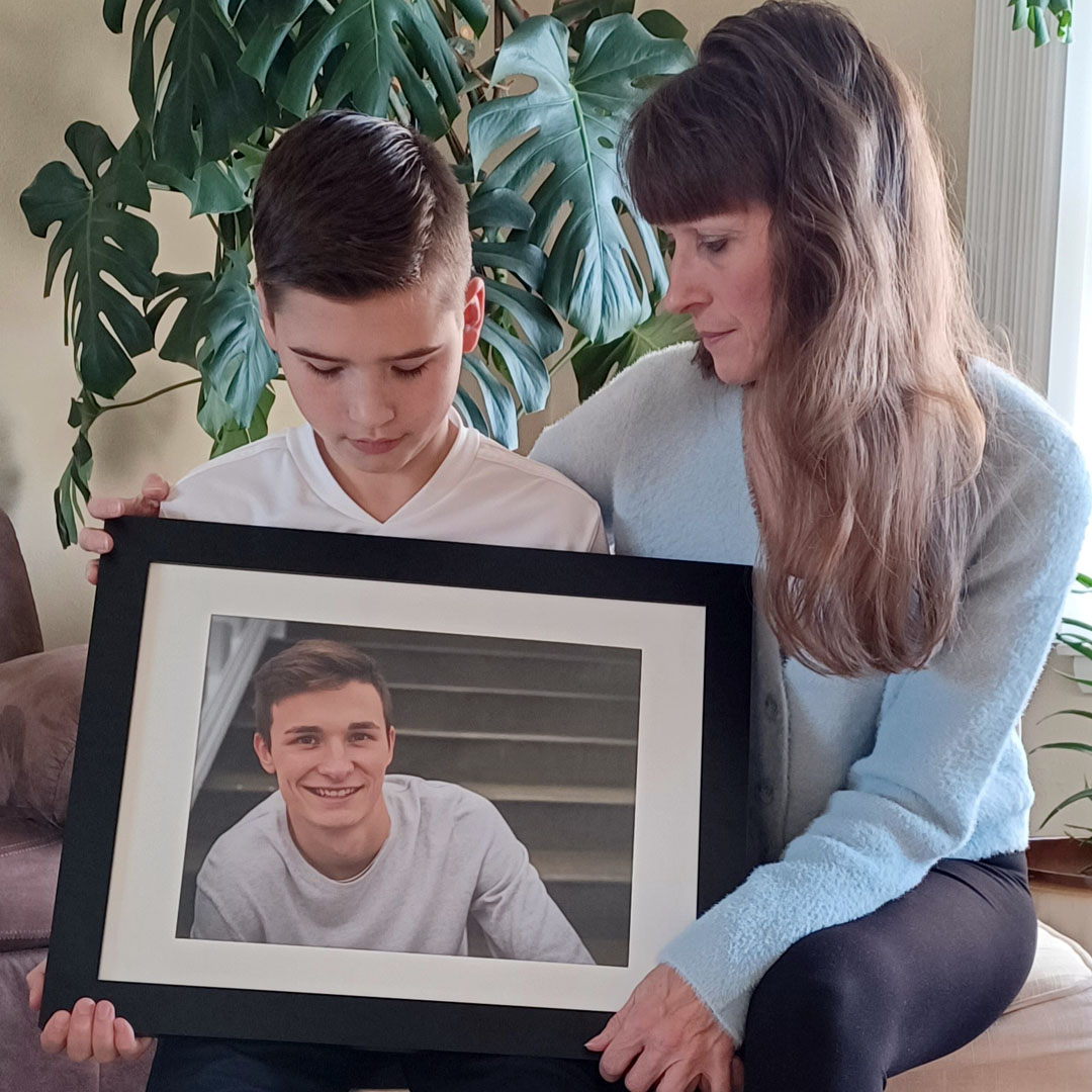 Individual holding up photo of a fallen worker