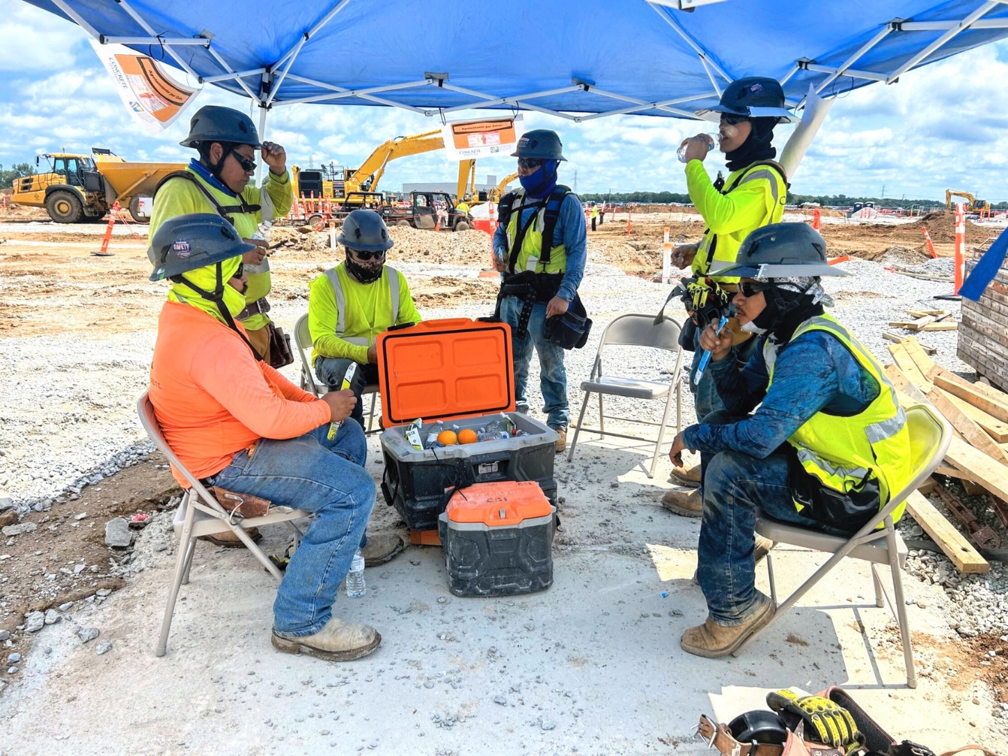 Concrete Strategies : workers under a shade canopy taking a break at an outdoor worksite