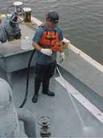 Figure 48: Worker washing barge deck with high pressure water.