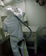 Figure 11: Worker using full body suit with airline respirator in enclosed space