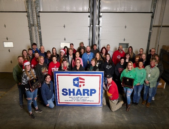 Haltec Corporation Salem, Ohio facility employees posing with their SHARP flag