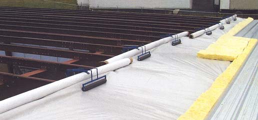 Depiction of installation of a row of insulation and metal roofing over sheet material with Purlin Glide system.