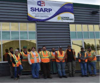 Employees at the Anchorage location with their SHARP flag