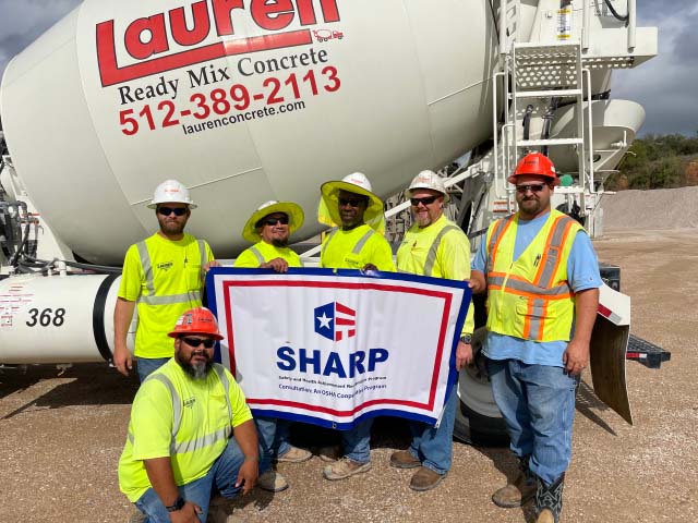 Employees stand with SHARP flag