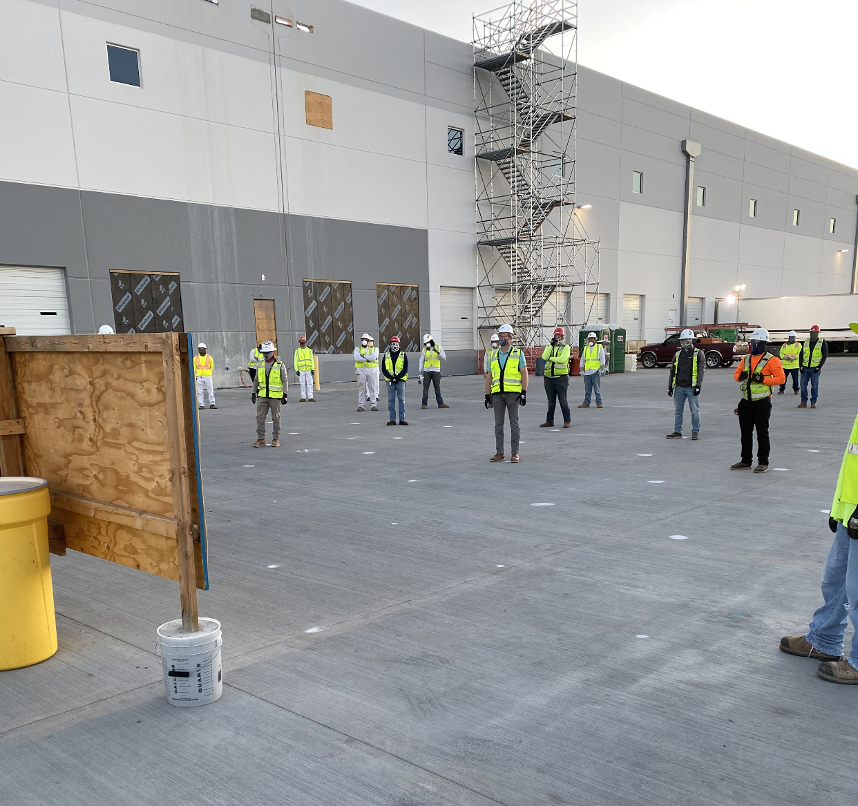 Photo of International Brotherhood of Electrical Workers (IBEW) conducting a safety meeting. Each standing six feet apart for social distancing during the Coronavirus Pandemic