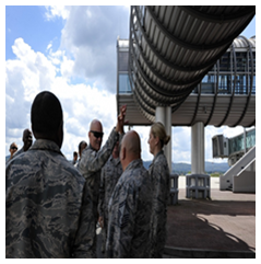 Airmen discussing fall protection equipment