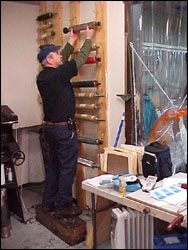 Figure 17. The operator is attempting to lift a 45 pound anilox roll above his head. Notice the box he has to stand on to reach it.