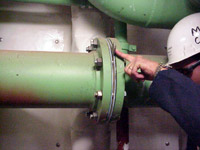 Figure 3: Marine Chemist verifying that piping into space to be cleaned is properly blanked off