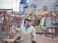 Figure 7: Burner wearing respirator, tinted face shield and leather gloves