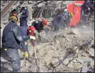 Rescue workers looking through debris - Copyright: OSHA