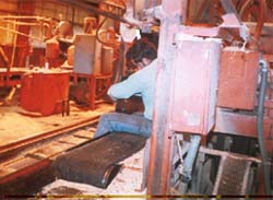 Worker sitting on belt conveyor. This is not a safe practice.