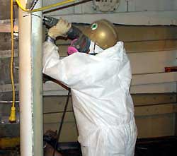 Figure 1: Worker using portable electric reciprocating saw, protected by respirator from inhalation hazards.