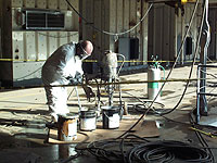 Figure 11: Worker protected by PPE from toxic paint fumes and spills while mixing paint.