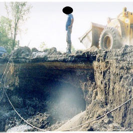 Yes-this is a violation. The excavation is undercutting the street and the front end loader only adds to the problem.