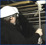 Image of worker inspecting suspension cables