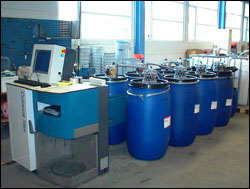 Figure 29. Ink dispenser hooked up to 8 drums and two totes. Ink is mixed and weighed on a platform at the bottom right of the computer. Recirculating pumps are located on the lids on top of the ink containers.