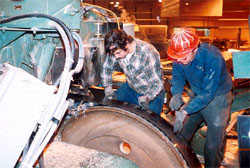 Workers changing band saw blade without locking out main disconnect.