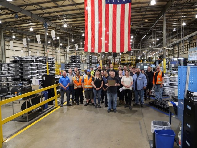 Company representatives standing with Gold award