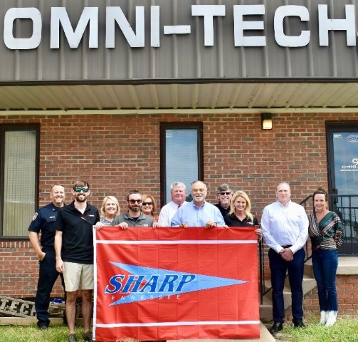 Omni-Tech Manufacturing Corporation Company officials holding the SHARP flag