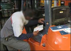 Figure 7. Operator checking the seat belt as part of the pre-operation inspection.