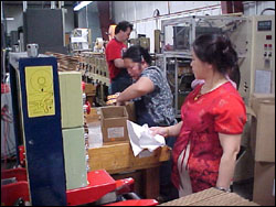 Figure 22. Employee must reach up and over sides of box to pack product.