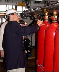 Figure 1. Fire extinguishing system specialist inspecting high pressure CO2 system on vessel.