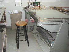 Figure 8. Work table is positioned at waist height and includes stool used for short seated rest breaks.