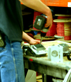 Employee using a tool to assemble something at a table