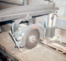 Unguarded lower blade and arbor end of radial saw