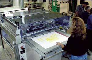 Figure 17. Loading paper for automated screen printing. Waist height loading table.