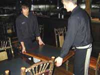 two young workers moving a table together.