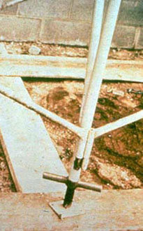 Figure 2. Proper foundation on wood sills: Scaffold end frames equipped with adjustable screw legs and with base plates set on mud (wood) sills.