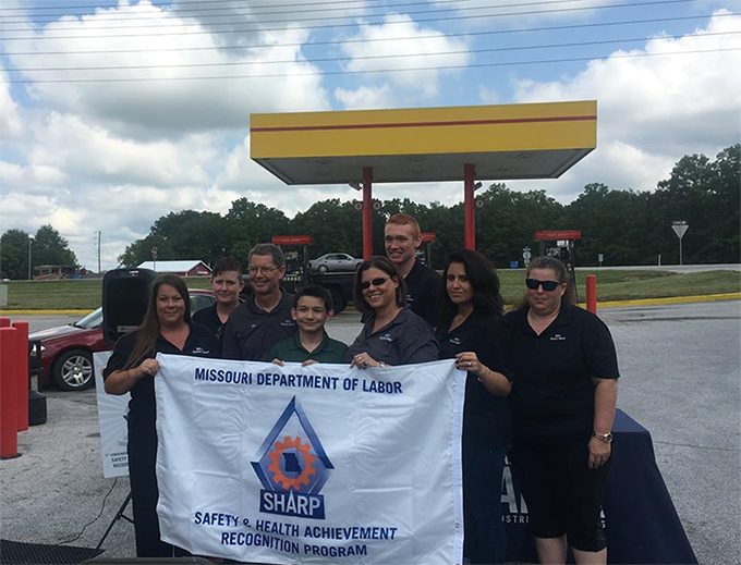 Holding the SHARP Flag, from Left to Right: Michelle Larkowski - Assistant Manager; Patt Langston - Cashier; Bill Spurlock - Owner; Aaron Collins - Cashier; Linda Collins - Vice President; Tommy Velier - Cashier; Erica Zavala – Cashier; and Jennifer Joh