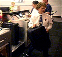 Ticket agents at workstations and moving baggage from counter