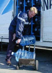 Fig. 1: Bending to place bottles on hand truck.