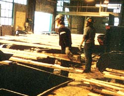 Workers at trim saw feed table