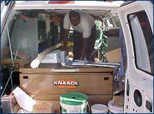 Figure 1. Employee crouching in a cluttered van.