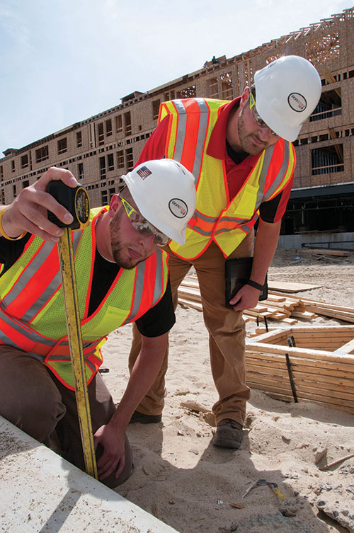 Photo by Karen Bachelder  Matt Hardy, construction safety consultant at WorkWISE NH (left), and intern Brady Keene, a senior at Keene State, measure a concrete ledge at A.W. Rose Construction's Bedford worksite.