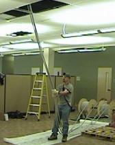 Figure 8 Using a pulley in the ceiling overhead allows employees to pull or guide wire without overhead arm positions.