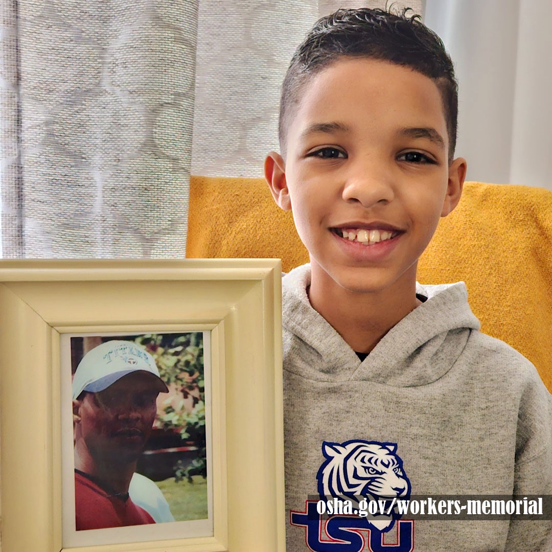 Individual holding up photo of a fallen worker