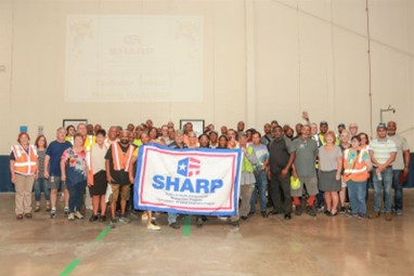 Company employees with the SHARP banner