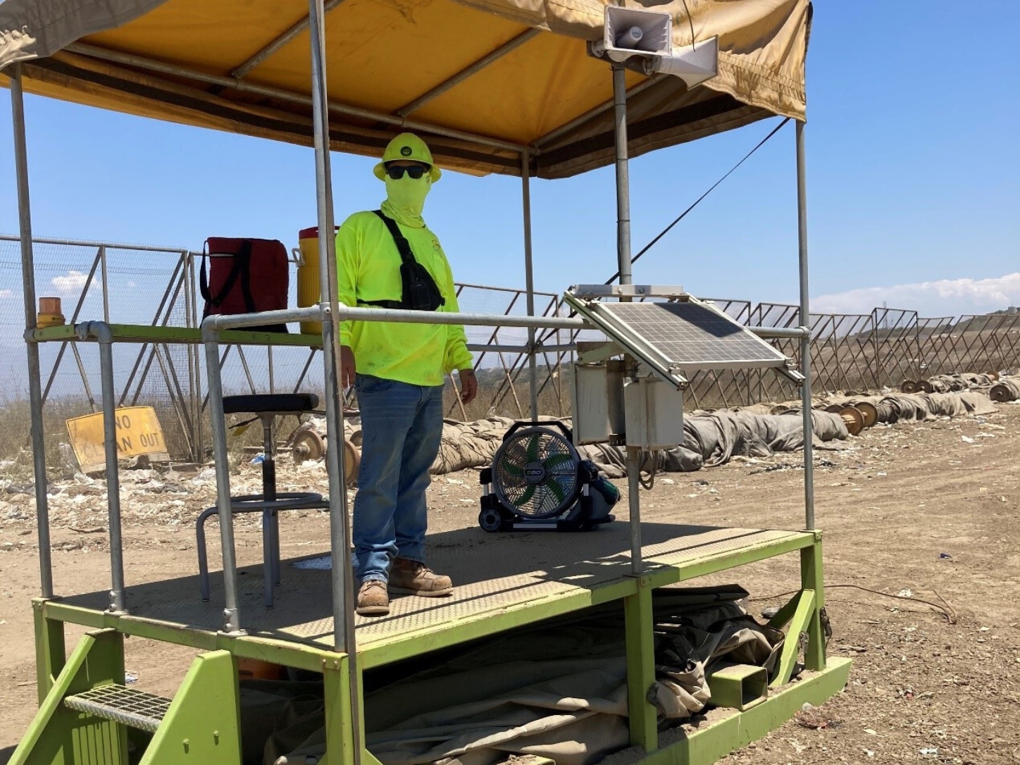 OC Waste & Recycling- Olinda Alpha Landfill : employee is equipped with a shaded spotter stand, a highchair, and a battery-operated misting fan