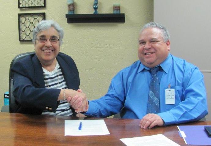 Caption: Margaret Arreola, David L. Carrasco Job Corps Center director (left) and Diego Alvarado Jr., OSHA area director in El Paso (right) sign the alliance agreement at the Job Corps center in El Paso.