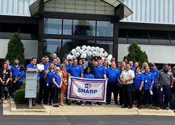 Employees standing with their SHARP flag.