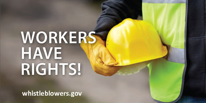 Worker wearing safety vest and gloves holding hardhat