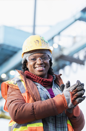 Smiling woman on construction site wearing personal protective equipment